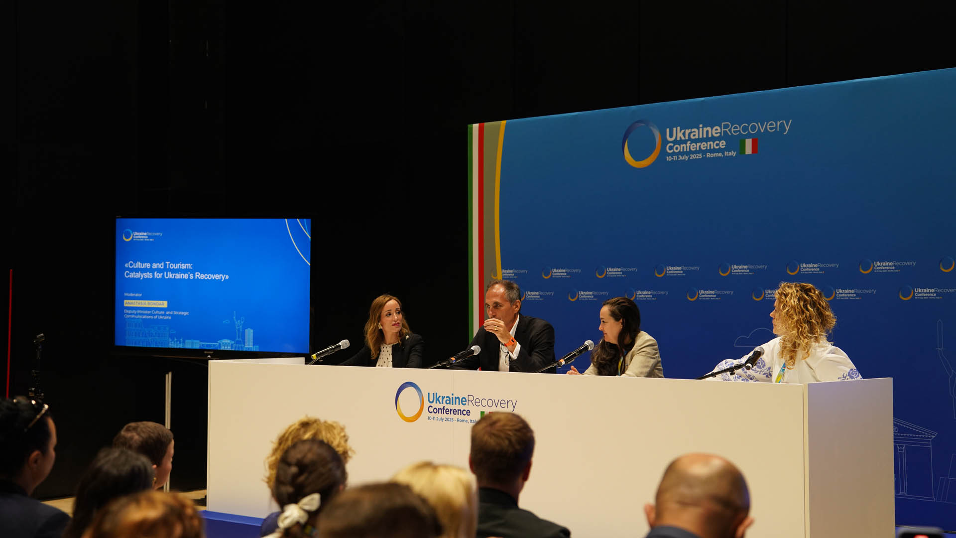 Wide view of a Ukraine Recovery Conference panel discussion, stage and audience